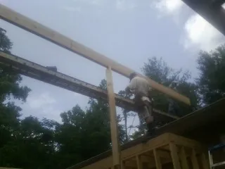 Carpenter setting a ridge beam over a new addition frame — Ice Dam Removal by Roofing Brothers in Rosenberg