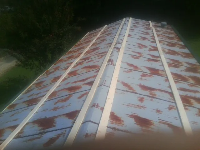 Rusted metal roof panels with new wood purlins before replacement — Storm Damage Roof Repair in Rosenberg by Roofing Brothers