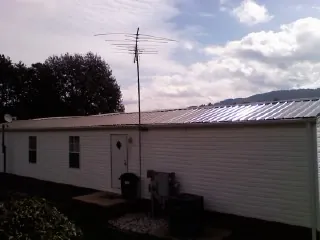 New metal roof on a single wide mobile home with a TV antenna in Rosenberg