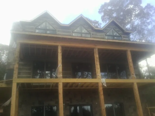 Dormers and porch framing on a large log home under construction — Roof Coating work by our crew in Rosenberg